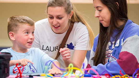 boy talking with two female student volunteers