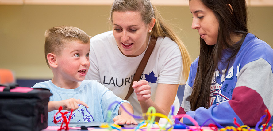 boy talking with two female student volunteers