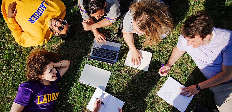 students doing homework on the lawn