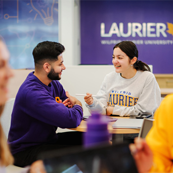 male and female students talking at table