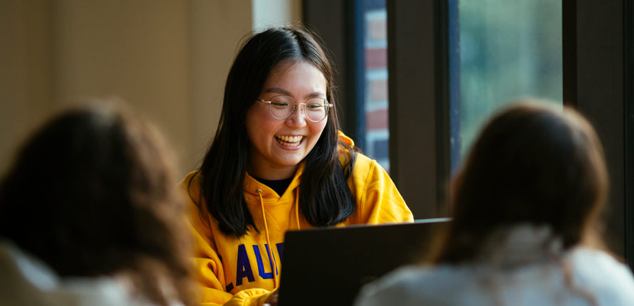 Student searching for resources on bookshelf