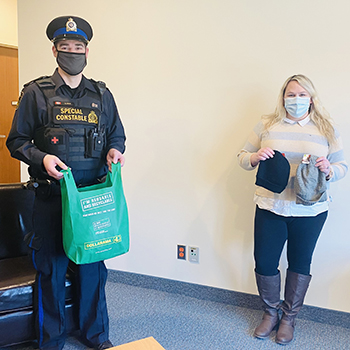 Staff members hold cold weather kits