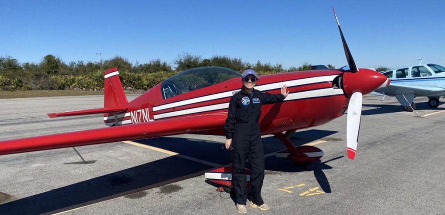 Kristin Cobbett standing in front of an airplane.