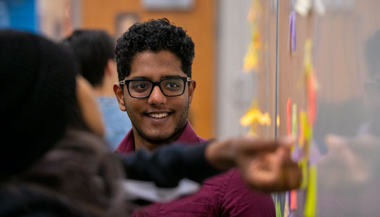 student works at white board